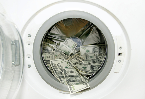 machine à laver avec à l'intérieur plusieurs billets de banque